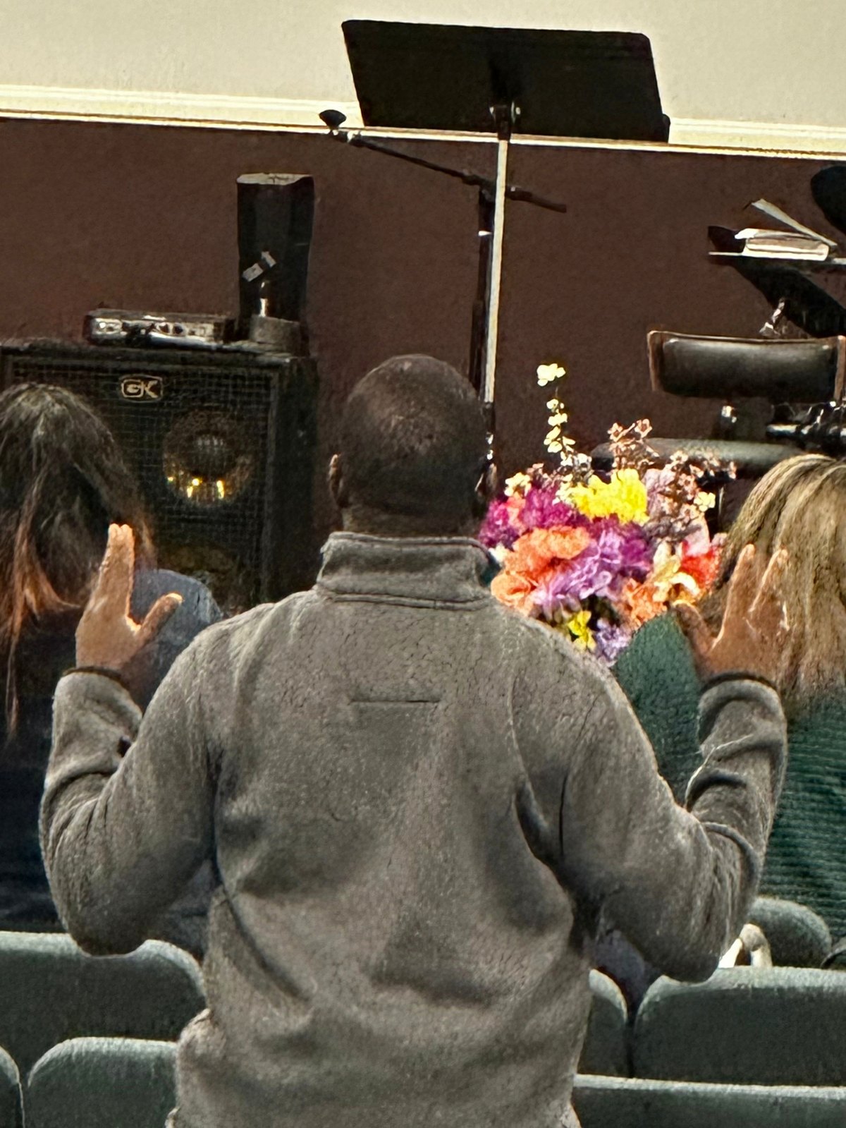 Hands raised in worship during a Sunday evening service at Harmony Baptist Church